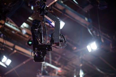 Low angle view of camera and illuminated lighting equipment in studio