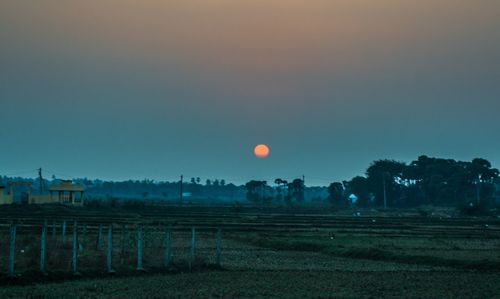 Scenic view of field against sky at sunset