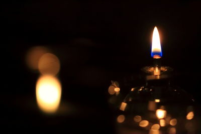 Close-up of lit candle in dark room