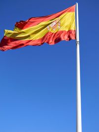 Low angle view of flag against blue sky