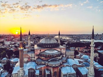 Buildings in city against sky during sunset