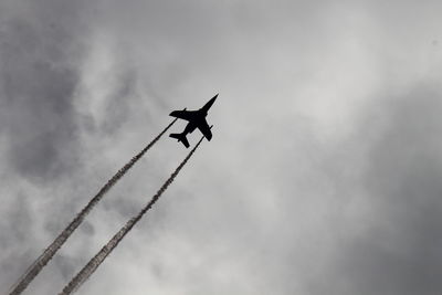 Low angle view of airplane flying against sky