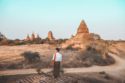 Rear view of man standing in front of historical building