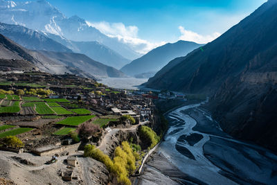 Scenic view of mountains in town against sky