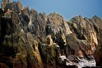 Low angle view of rock formations against sky