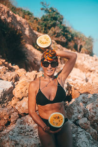 Woman wearing sunglasses standing on rock
