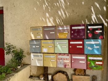 Close-up of rows of colourful mailboxes against wall