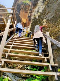 Rear view of people walking on staircase