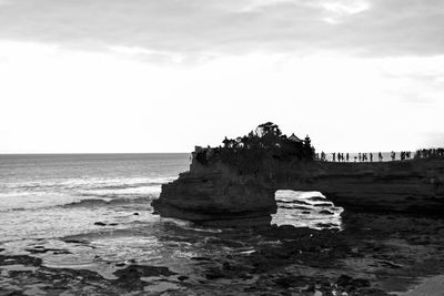 Rock formation on beach against sky