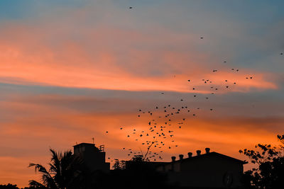 Low angle view of silhouette buildings against sky during sunset