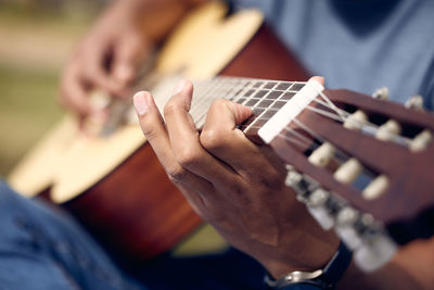 Midsection of man playing guitar