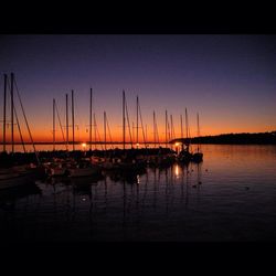 Sailboats in sea at sunset