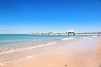 Scenic view of beach against clear blue sky