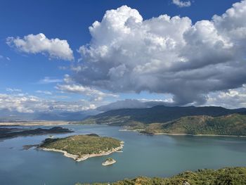 Scenic view of lake by mountains against sky