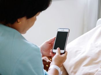 Cropped image of woman using smart phone at home