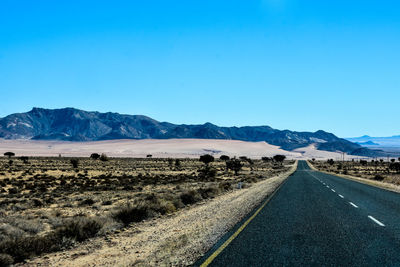 Empty road along countryside landscape