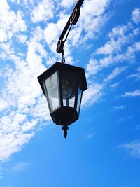 Low angle view of lantern hanging on street light against sky