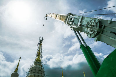 Low angle view of cranes against sky