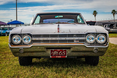 Vintage car on field against sky