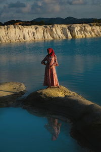 Man standing on rock by lake
