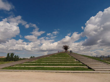 People walking on footpath against sky