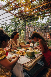 Family having food at dining table under illuminated gazebo at resort on vacation