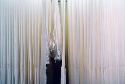 Person seen through torn curtain