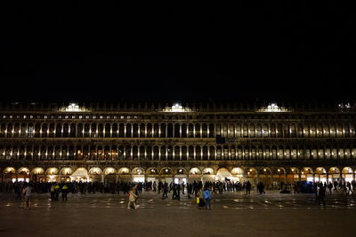 Group of people in illuminated building at night