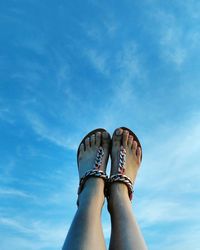 Low section of woman against blue sky