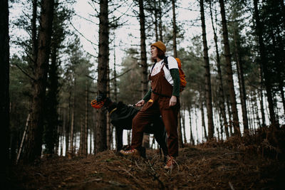 Rear view of woman standing in forest