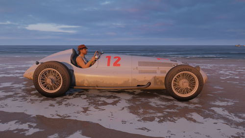 Vintage car on beach against sky