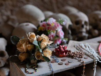 Close-up of rose bouquet on table against human skull