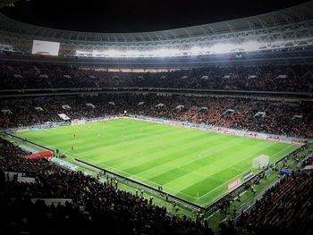 Crowd playing soccer on field