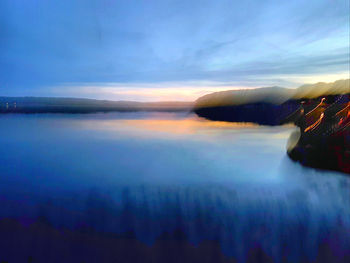 Scenic view of lake against sky at sunset