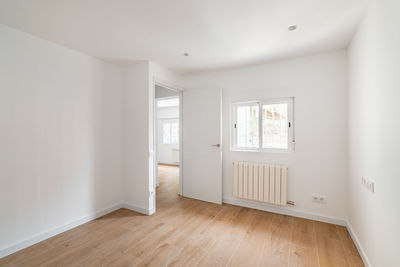 Empty room with window and hardwood floor after renovation. new apartment for rent or sale.