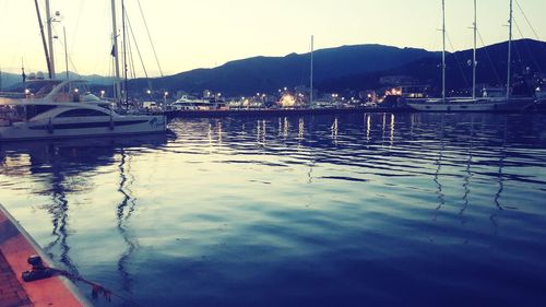 Sailboats moored in harbor against sky