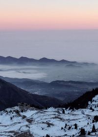 Scenic view of snow covered mountains against sky during sunset
