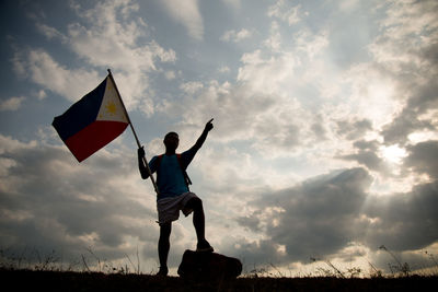 Man standing on field against sky during sunset