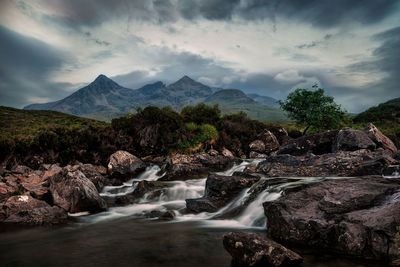 Scenic view of waterfall against sky