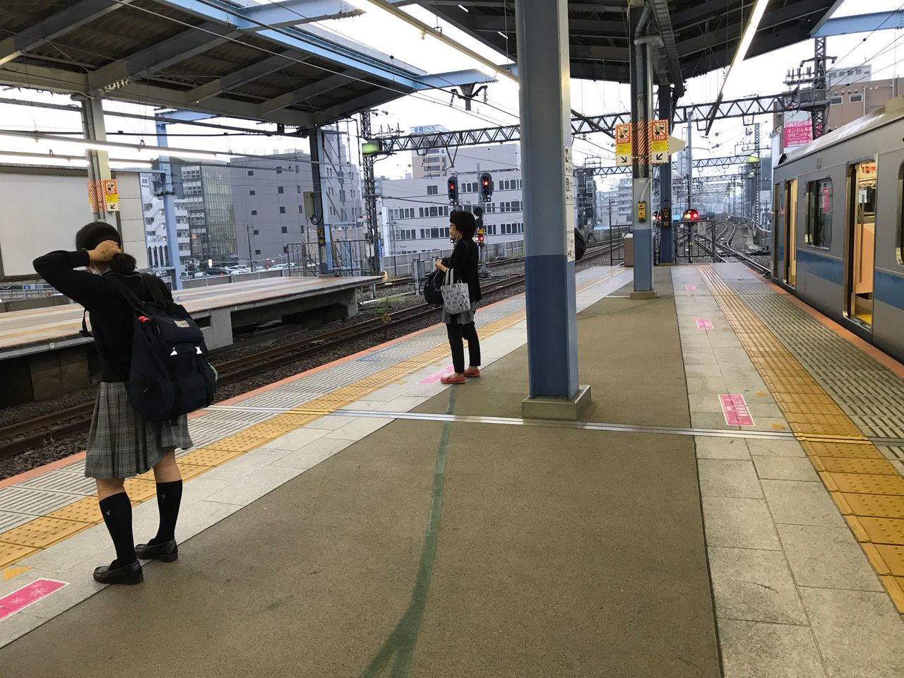 transportation, railroad station platform, public transportation, railroad station, train - vehicle, rail transportation, mode of transport, real people, waiting, full length, men, passenger, railroad track, travel, journey, land vehicle, women, station, standing, indoors, lifestyles, built structure, subway train, architecture, day, people