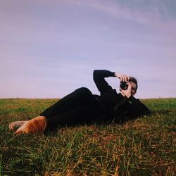 Dog relaxing on grassy field