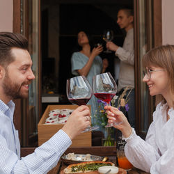 Side view of young woman having food at home