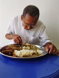 Man eating food in plate at home