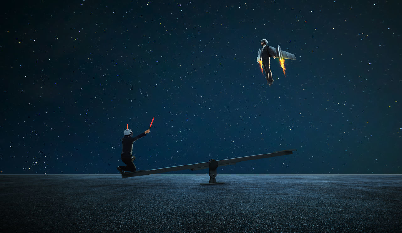 PEOPLE JUMPING AGAINST STAR FIELD AT NIGHT SKY