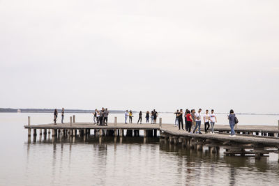 Group of people on boat in sea against sky