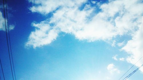 Low angle view of power lines against blue sky