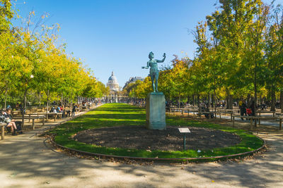 Statue in park against sky in city