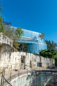 Building by swimming pool against clear blue sky