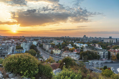 High angle view of trees and buildings against sky during sunset