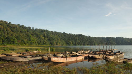 Boats moored on lake against sky